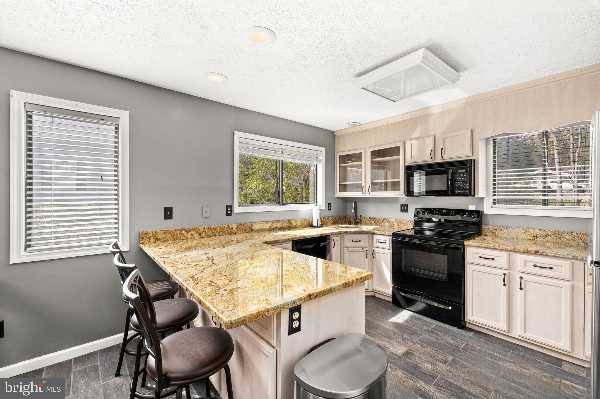 128 Harrison Circle Locust Grove, VA 22508 - Photo 6 of 65 a kitchen with a stove a sink dishwasher a dining table and chairs with wooden floor