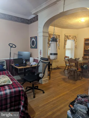 a living room with furniture and a wooden floor