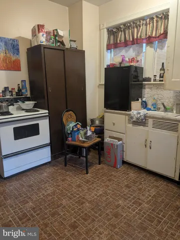 a living room with furniture a flat screen tv and kitchen view