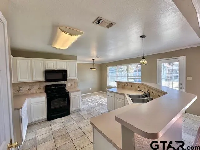 a kitchen with stainless steel appliances granite countertop a sink and a stove