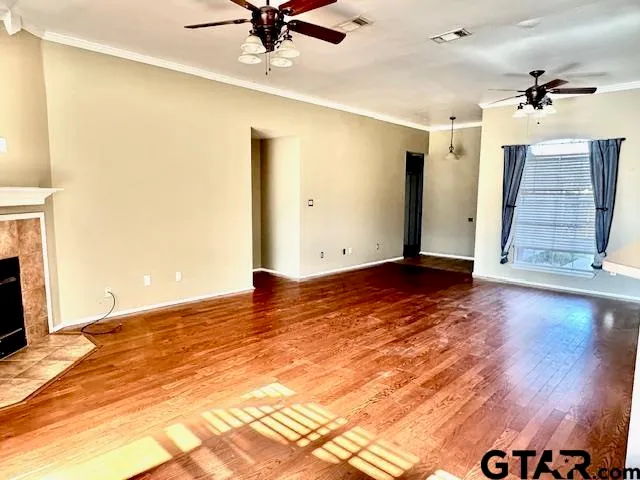 a view of empty room with wooden floor
