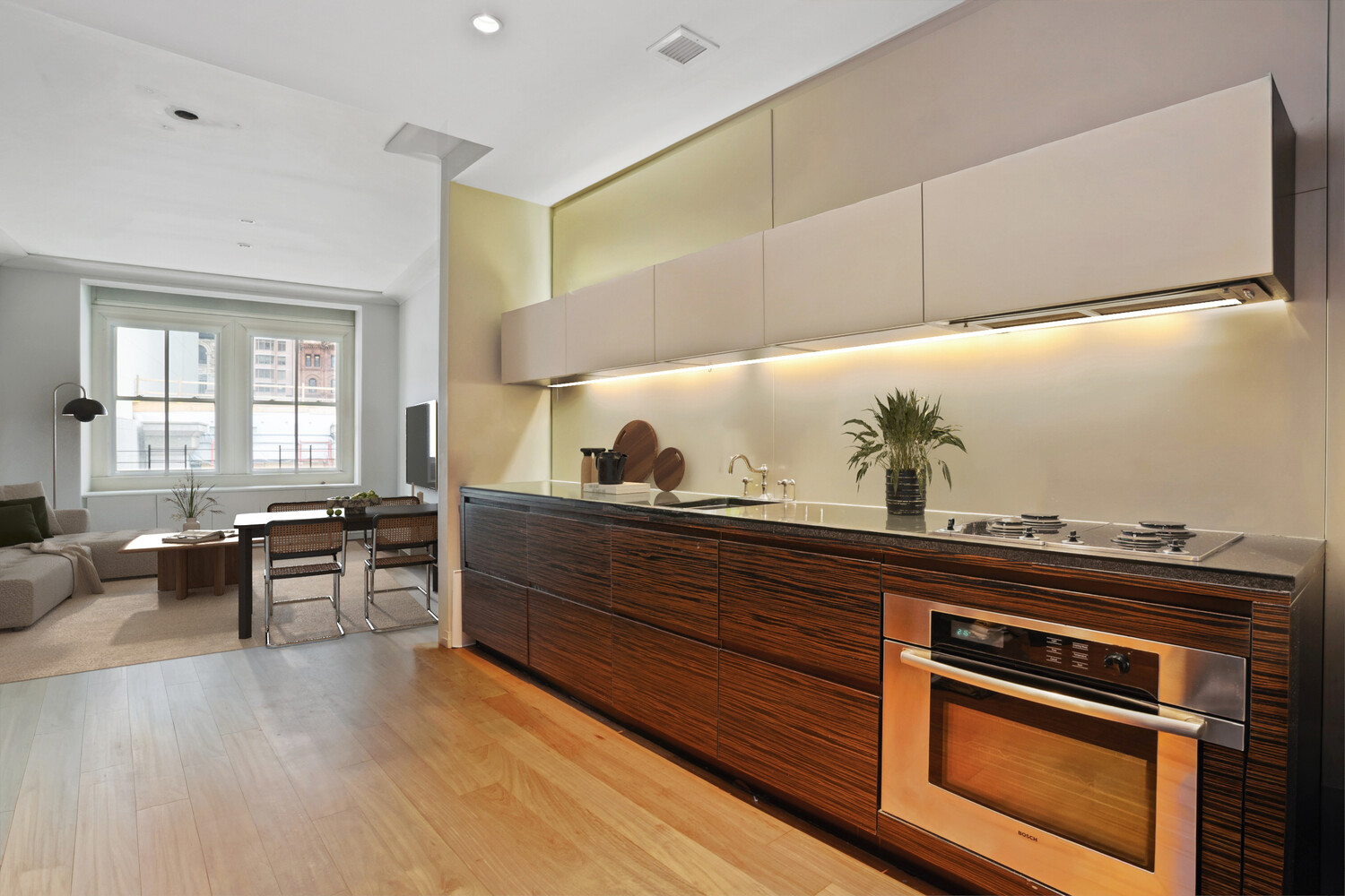 55 Wall Street, Unit 834 Manhattan, NY 10005 - Photo 3 of 10 a living room with stainless steel appliances kitchen island granite countertop a stove a sink and a refrigerator
