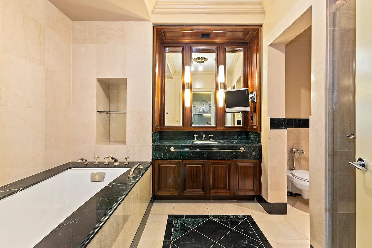 55 Wall Street, Unit 834 Manhattan, NY 10005 - Photo 5 of 10 a bathroom with a bathtub and a sink