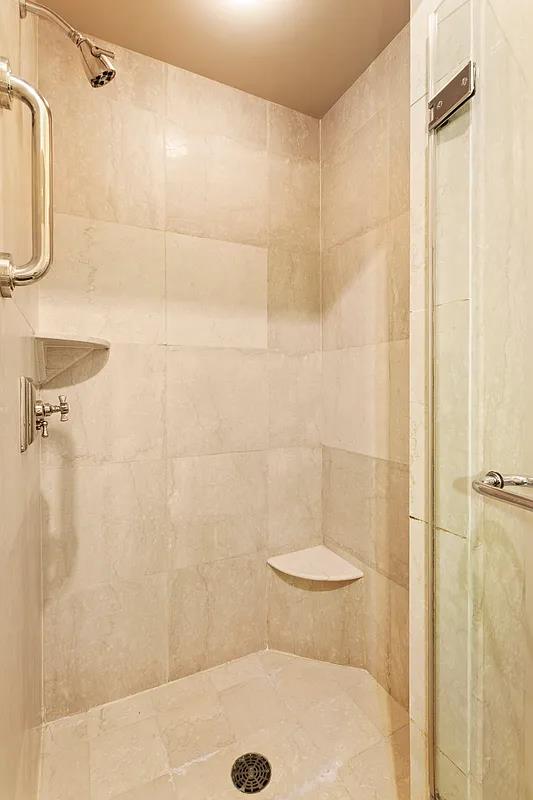 55 Wall Street, Unit 834 Manhattan, NY 10005 - Photo 6 of 10 a bathroom with a shower and a toilet
