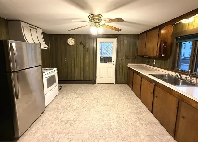 a kitchen with stainless steel appliances granite countertop a refrigerator a stove and a sink with cabinets