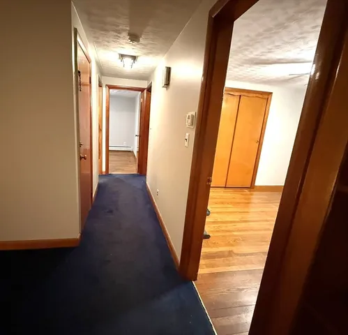 a view of a hallway with wooden floor and stairs