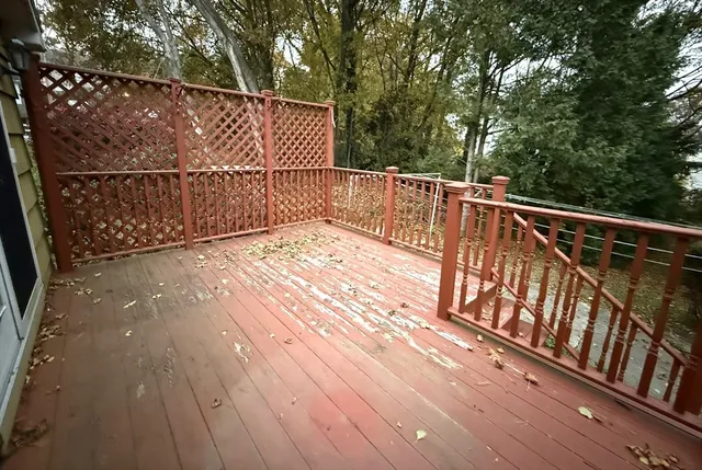 a view of balcony with wooden floor and fence