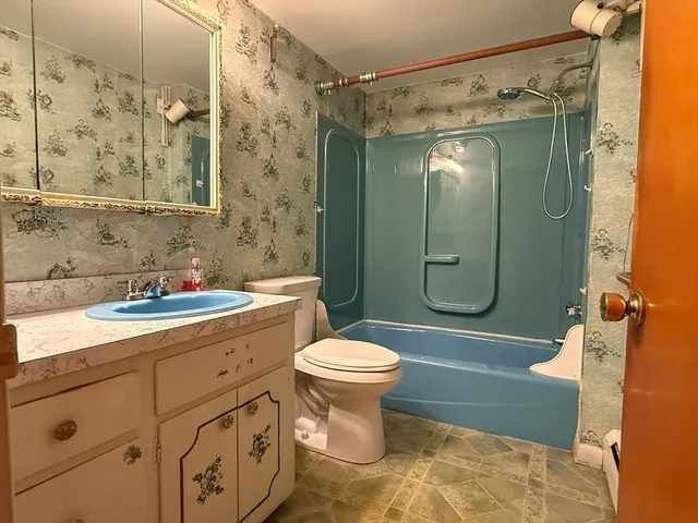 a bathroom with a granite countertop sink toilet and shower