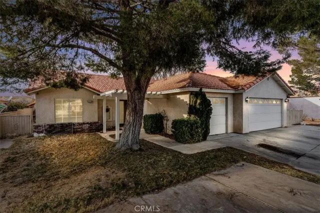 a view of a house with a tree next to a yard