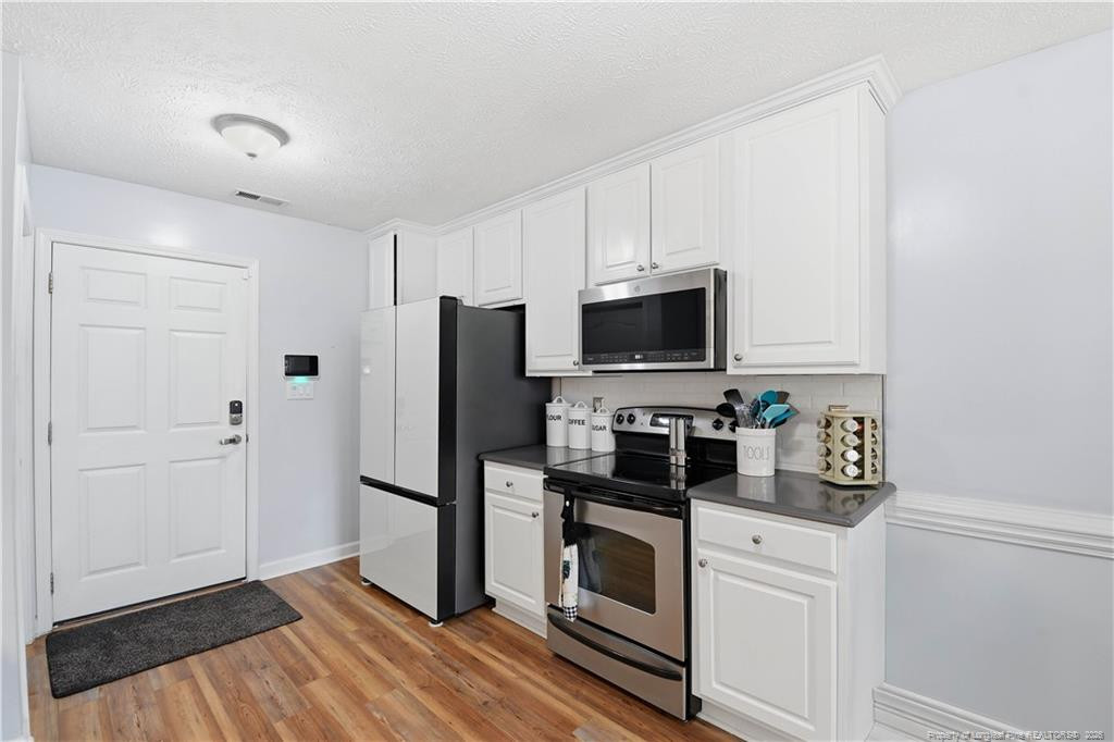 212 Lennox Loop Raeford, NC 28376 - Photo 15 of 47 a kitchen with a refrigerator stove and microwave