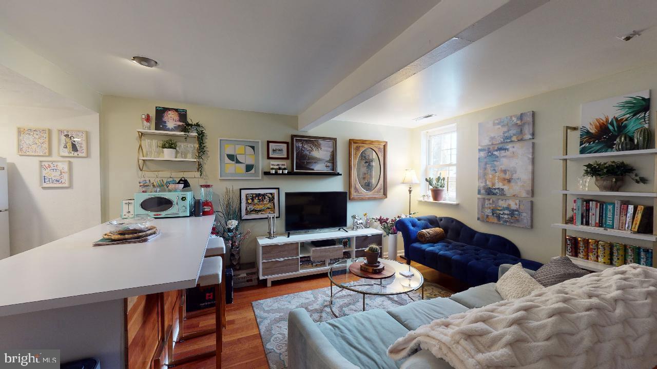 1018 Pine Street, Unit 3F Philadelphia, PA 19107 - Photo 2 of 10 a living room with furniture a bookshelf and a flat screen tv