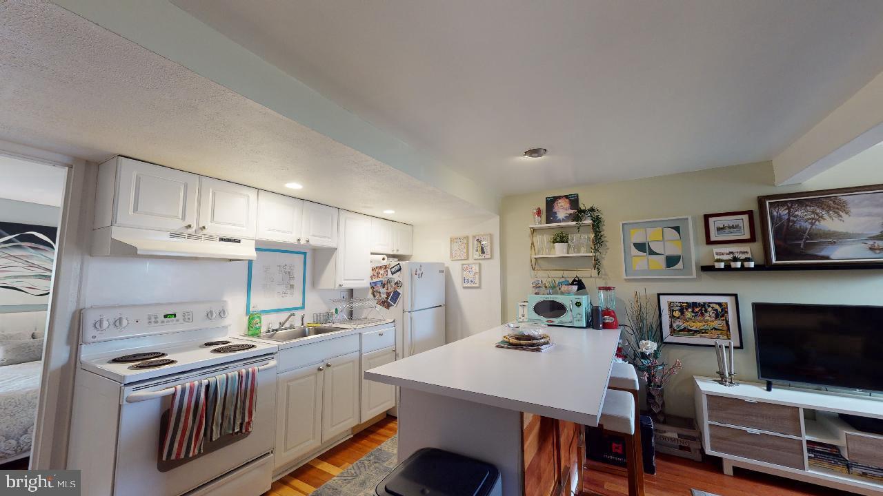 1018 Pine Street, Unit 3F Philadelphia, PA 19107 - Photo 4 of 10 a kitchen with stainless steel appliances a stove a sink a microwave a counter top space and cabinets