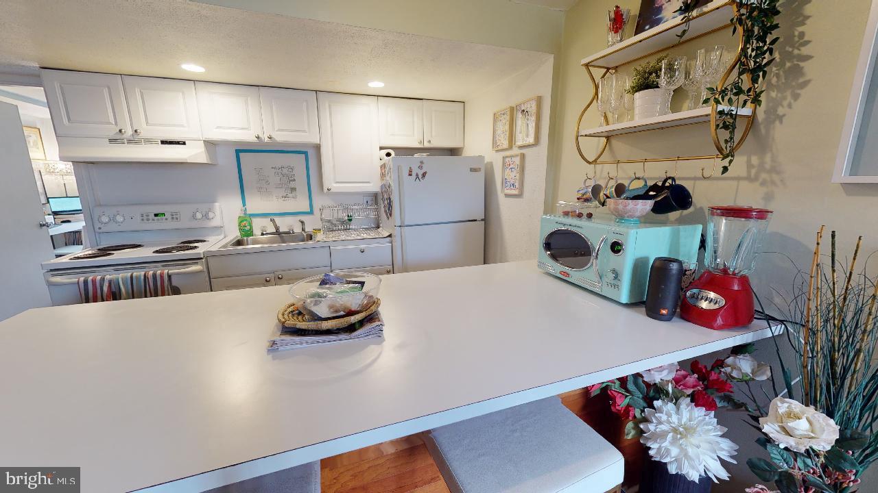 1018 Pine Street, Unit 3F Philadelphia, PA 19107 - Photo 5 of 10 a kitchen with granite countertop a white refrigerator a stove and a sink