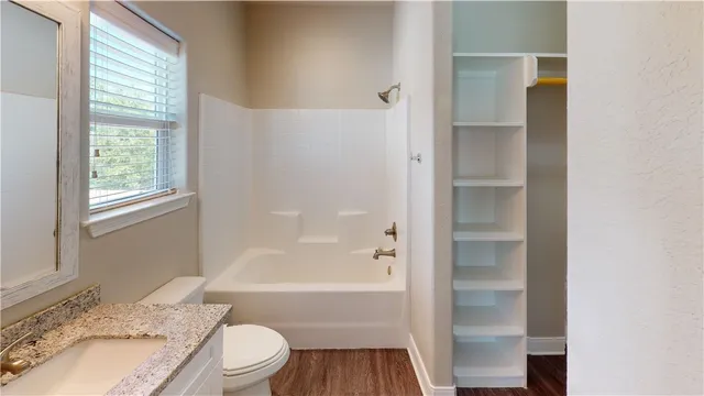 a bathroom with a granite countertop sink toilet and shower