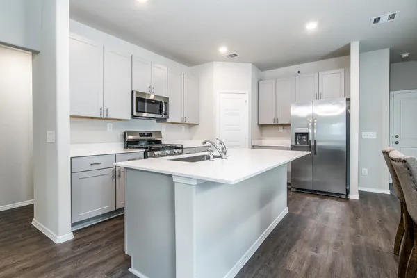 a kitchen with stainless steel appliances a refrigerator sink and microwave