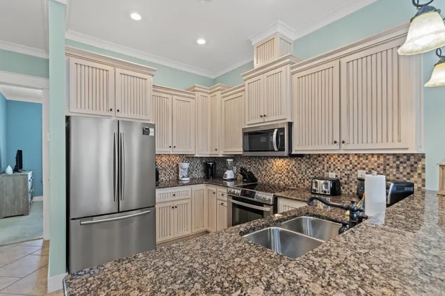 a kitchen with stainless steel appliances granite countertop a sink a stove and a refrigerator