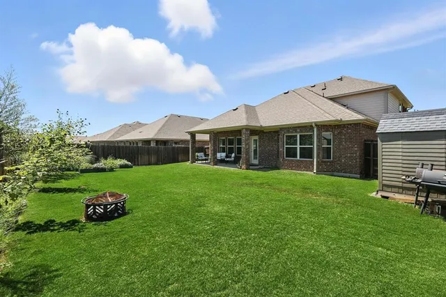 a view of a house with a small yard and wooden fence