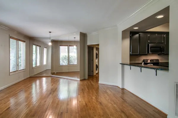 a view of hallway with a window and wooden floor