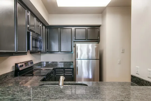 a kitchen with a refrigerator and a stove top oven