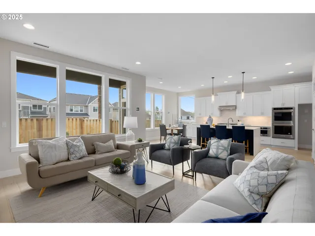 a living room with furniture kitchen view and a large window