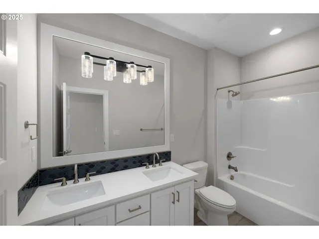 a bathroom with a sink toilet a mirror and shower