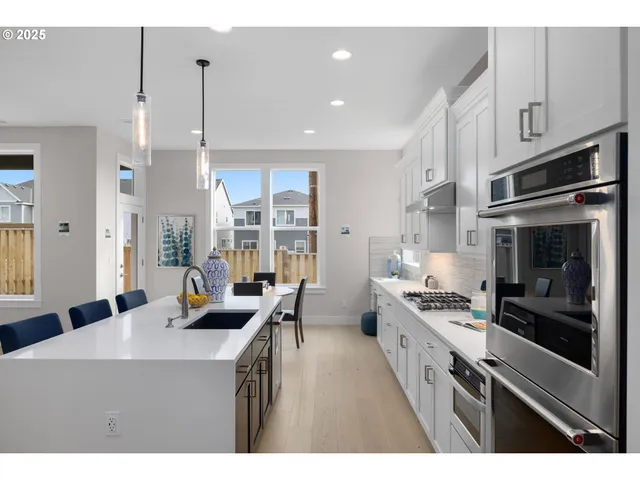 a kitchen with stainless steel appliances kitchen island granite countertop a stove a sink a refrigerator and a wooden cabinets