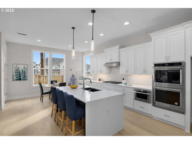 a kitchen with appliances a sink a counter top space and cabinets