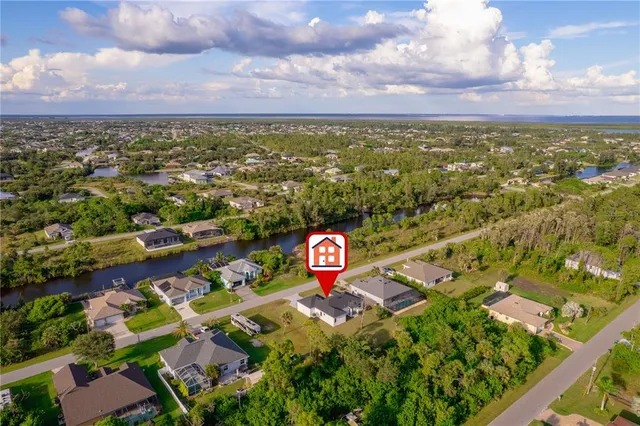 an aerial view of residential houses with outdoor space and trees