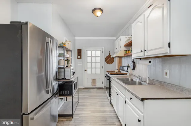 a kitchen with stainless steel appliances granite countertop a refrigerator and a stove