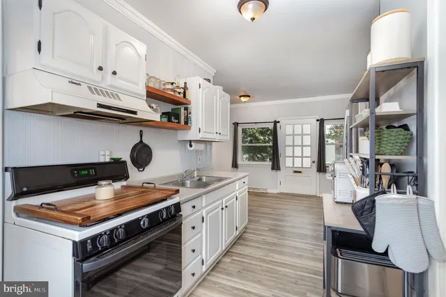 a kitchen with a stove and a wooden floors