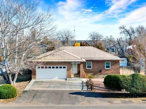 a front view of a house with a garden and trees