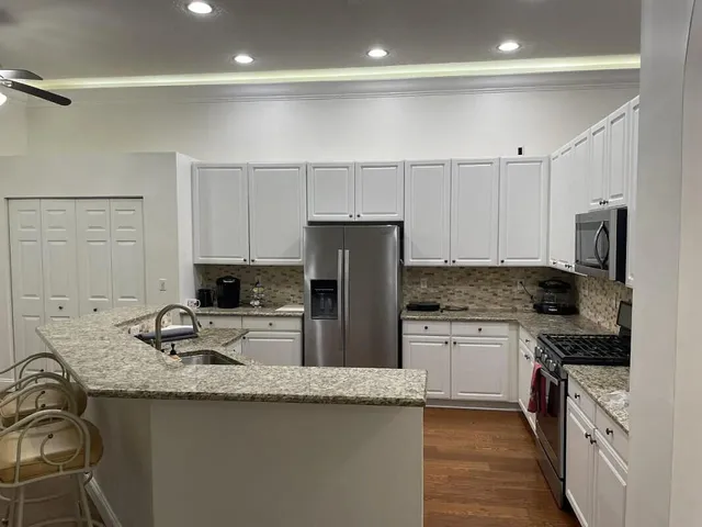 a kitchen with granite countertop a sink stove and refrigerator