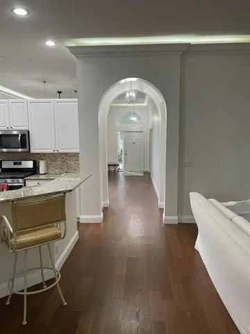 a hallway with wooden floors and white walls
