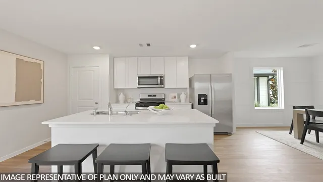 a kitchen with a dining table chairs and refrigerator