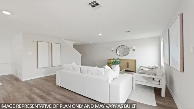 a living room with furniture a rug and white walls