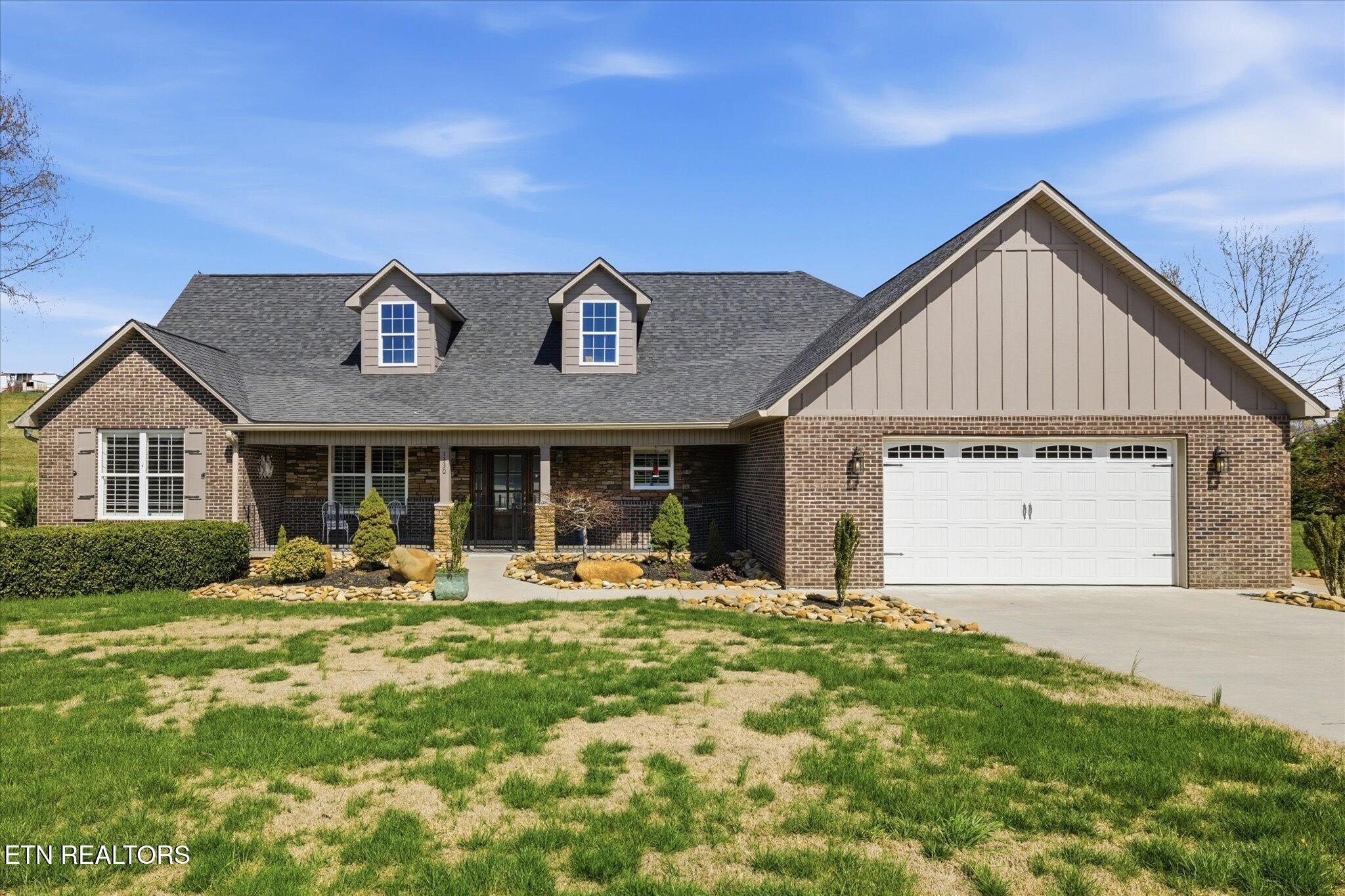 a front view of a house with yard outdoor seating and garage