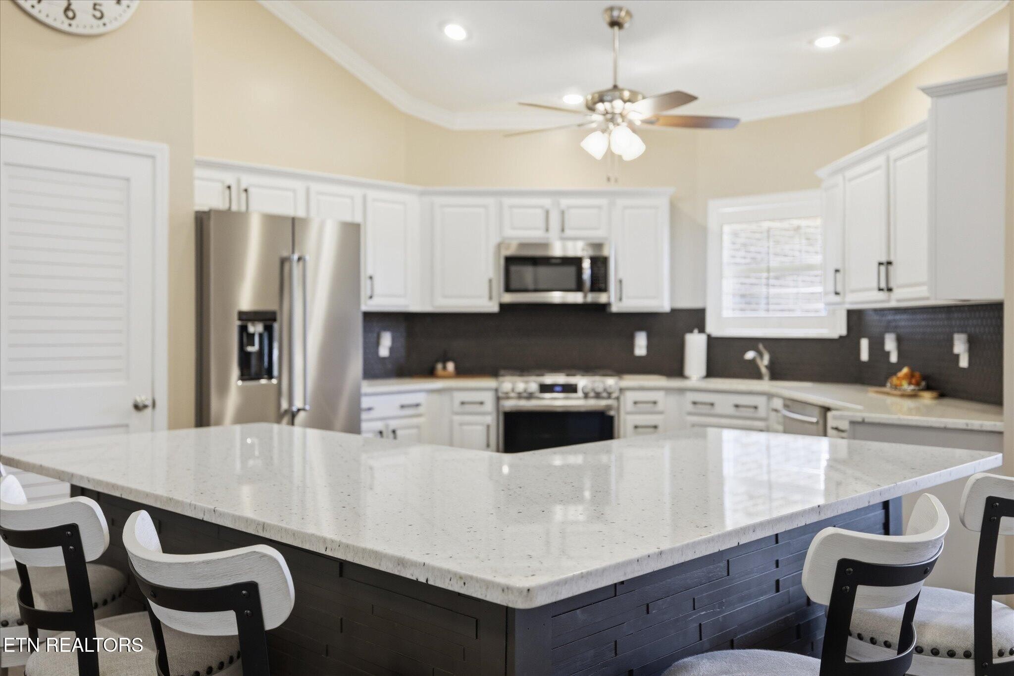 1330 Rippling Waters Circle Sevierville, TN 37876 - Photo 12 of 53 a kitchen with kitchen island granite countertop a stove a sink a microwave a dining table and chairs
