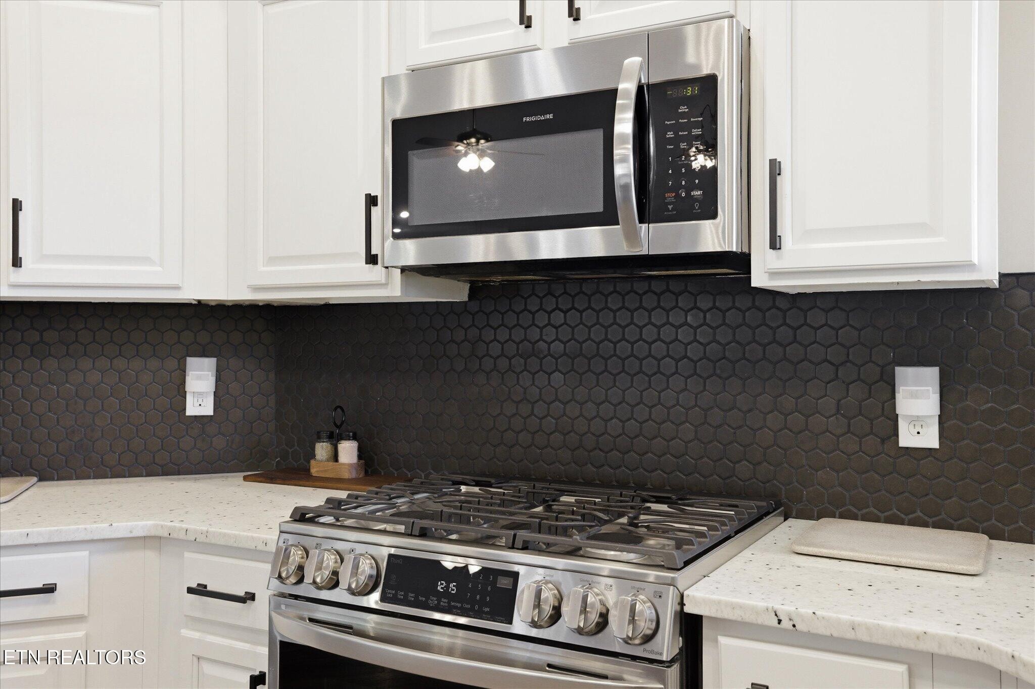 1330 Rippling Waters Circle Sevierville, TN 37876 - Photo 15 of 53 a stove top oven sitting inside of a kitchen