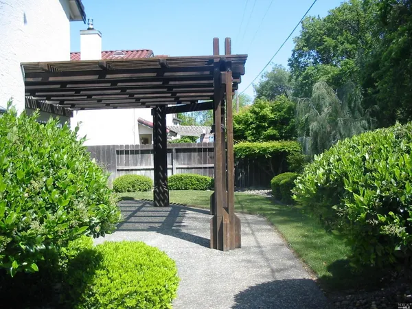 a view of a patio with table and chairs and a large tree