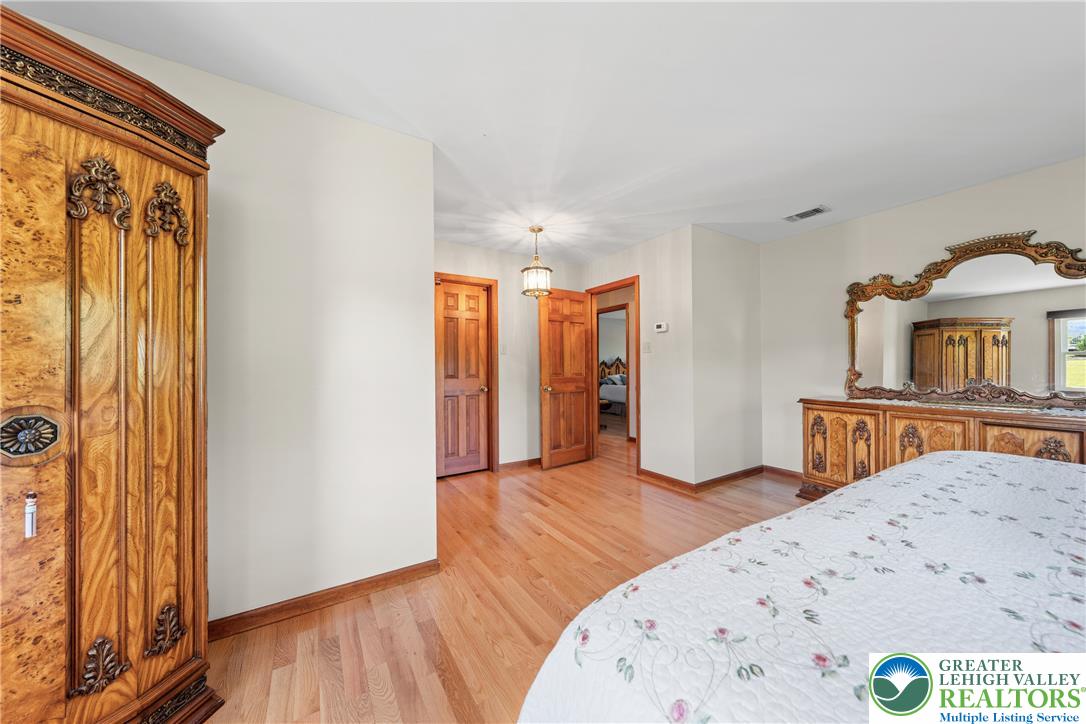 947 Tamenend Road Bath, PA 18014 - Photo 26 of 61 Hardwood floors stretch across this naturally illuminated bedroom with classic architectural details.