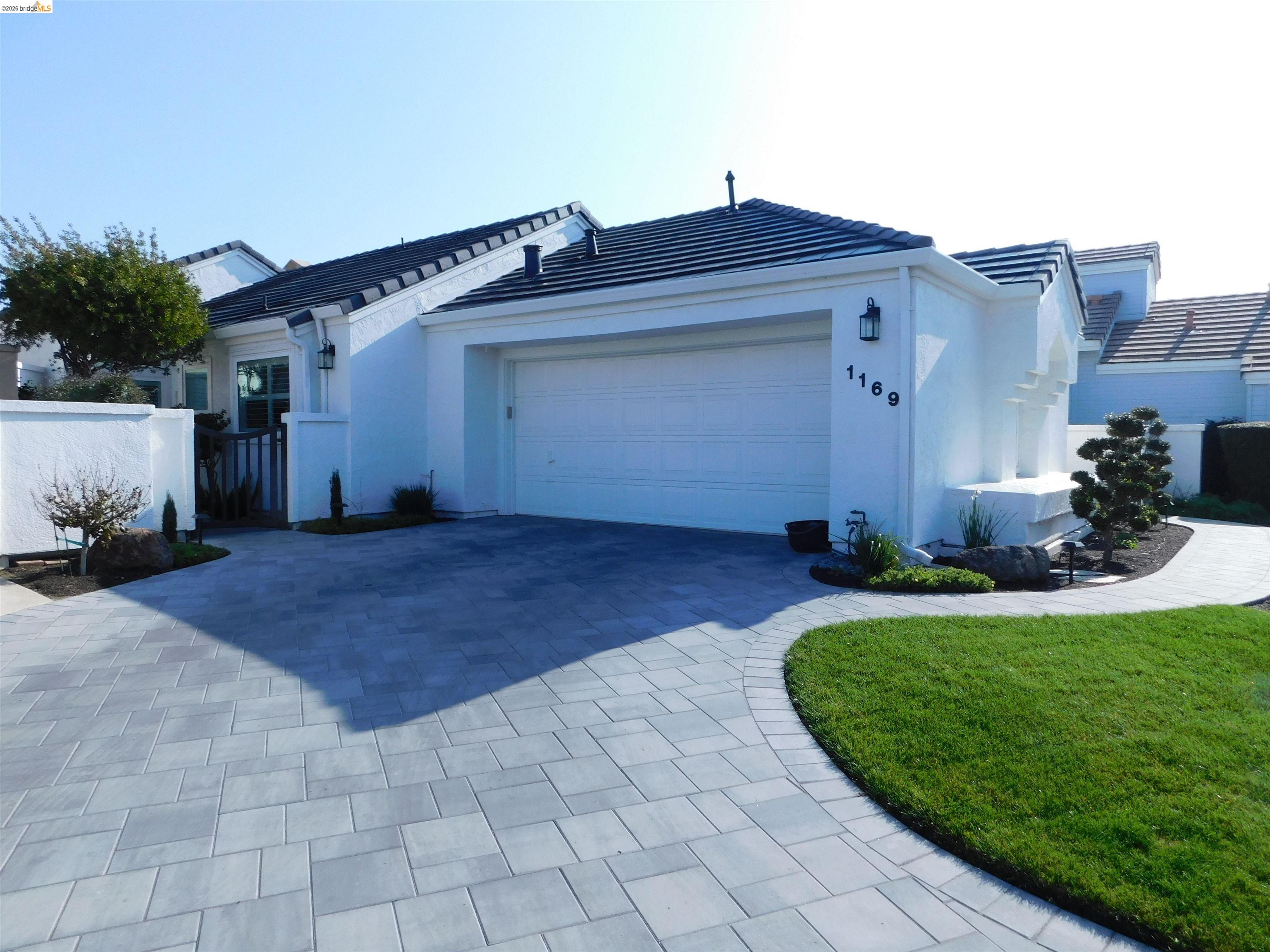 a view of a house with a big yard and large tree