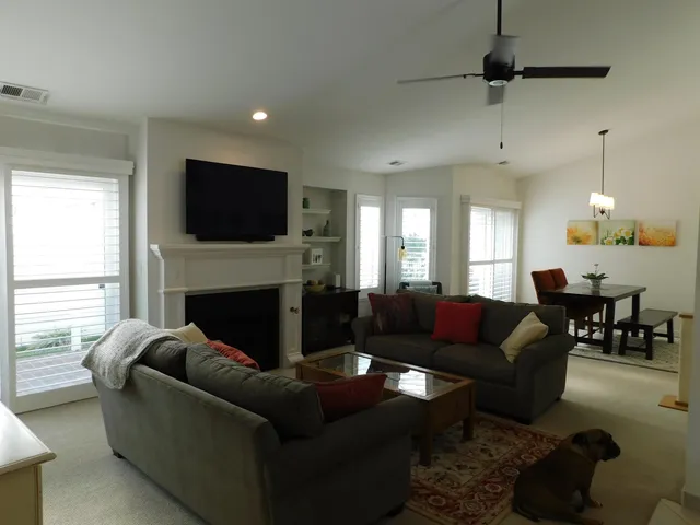 a living room with furniture a fireplace and a flat screen tv