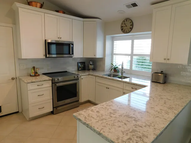 a kitchen with stainless steel appliances granite countertop a sink a stove and a granite counter tops