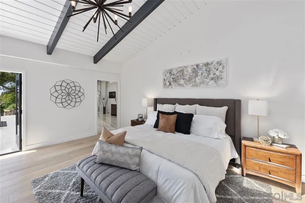 5780 Rutgers Road La Jolla, CA 92037 - Photo 15 of 25 a bedroom with a large bed and a chandelier