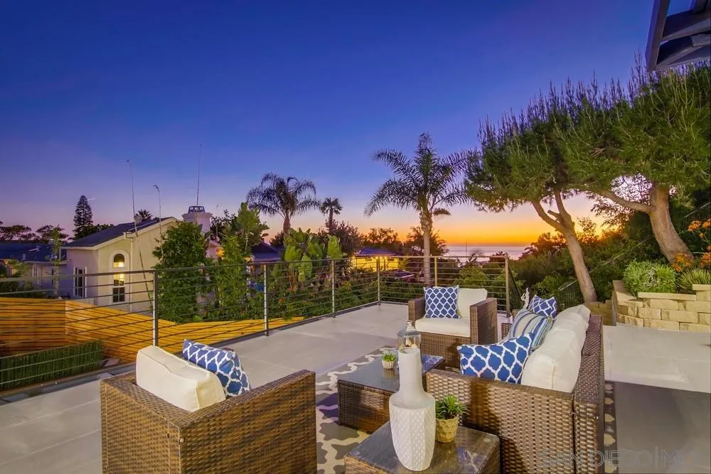 5780 Rutgers Road La Jolla, CA 92037 - Photo 7 of 25 a view of a patio with couches chairs under an umbrella with palm trees