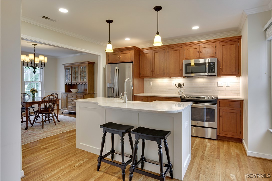 2706 Berkeley Pointe Drive Henrico, VA 23233 - Photo 17 of 48 a kitchen with kitchen island granite countertop a stove a sink a oven a dining table and chairs with wooden floor