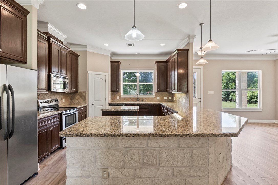 6701 Old Reliance Road Bryan, TX 77808 - Photo 9 of 44 a kitchen with stainless steel appliances granite countertop a sink a stove and a refrigerator