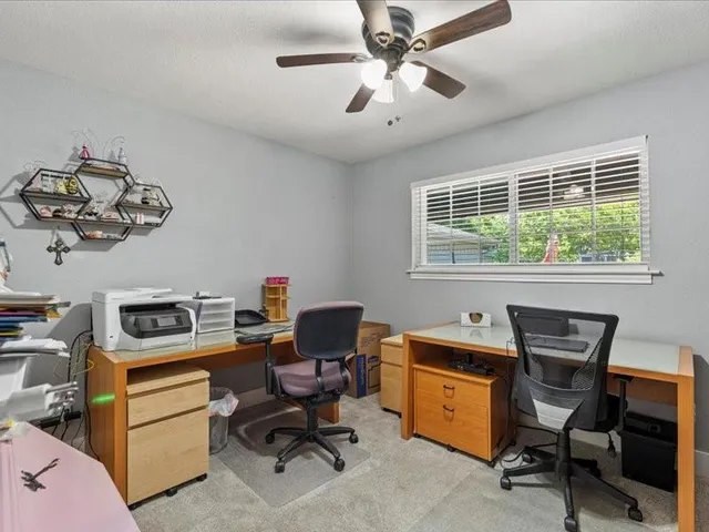 a view of a workspace with furniture and a window