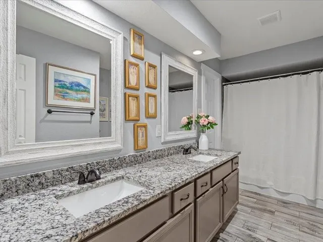 a bathroom with a granite countertop sink and a mirror