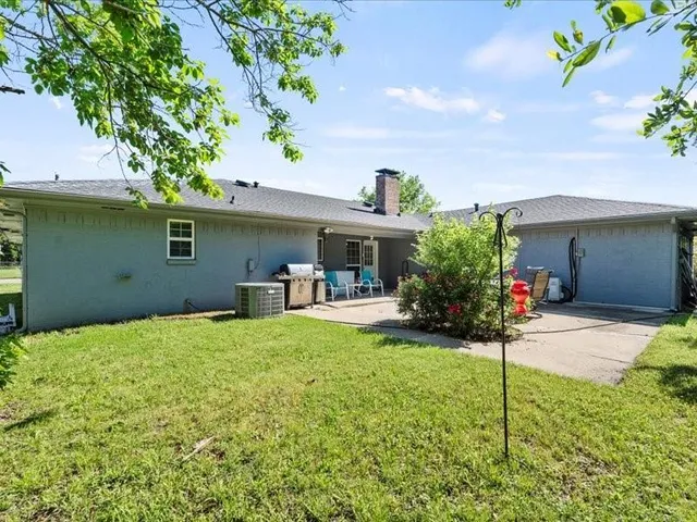 a view of a house with backyard and sitting area